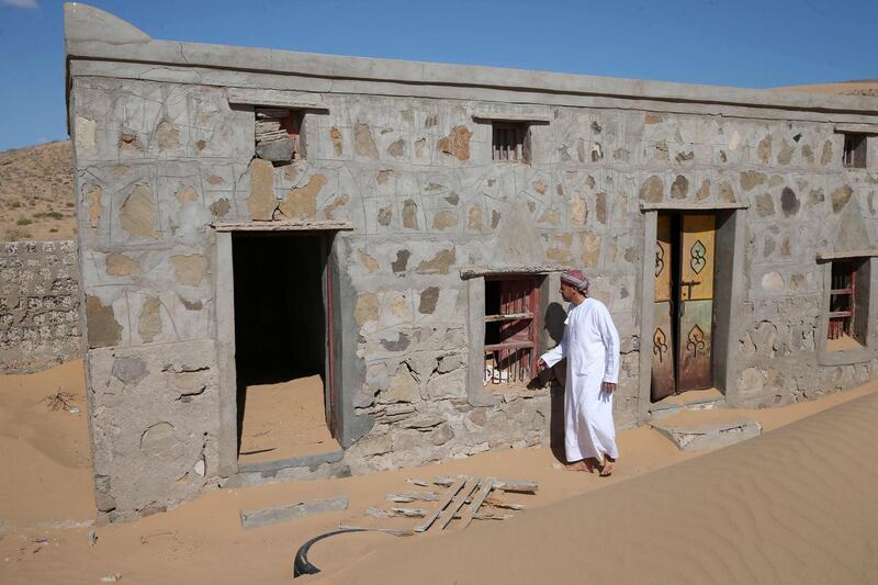 Mohammed al-Ghanbousi, a former inhabitant of Wadi al-Murr, stands next to his abandoned house in the Omani village. AFP