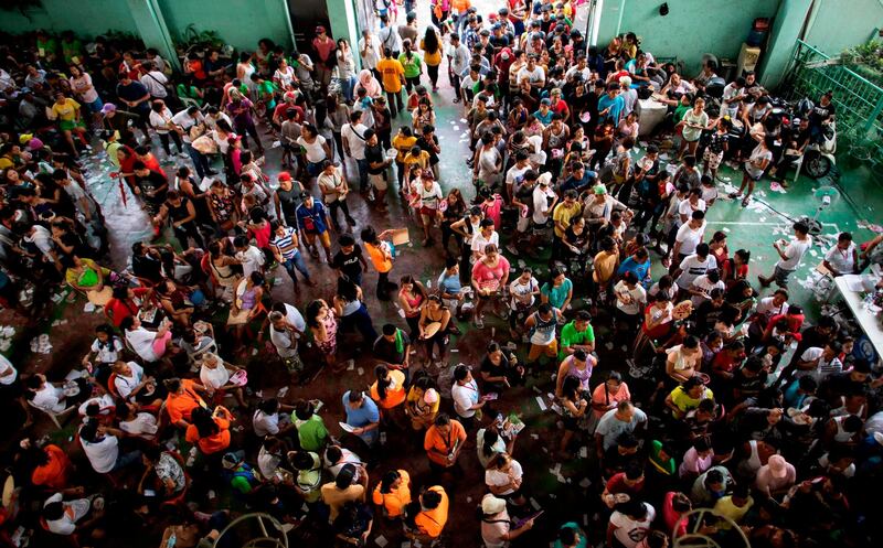 People wait for their turn to vote at Baseco Elementary School in Manila on May 13, 2019. Filipinos headed to the polls on May 13 in a vote that is expected to strengthen President Rodrigo Duterte's grip on power, opening the way for him to deliver on pledges to restore the death penalty and rewrite the constitution. / AFP / Noel CELIS
