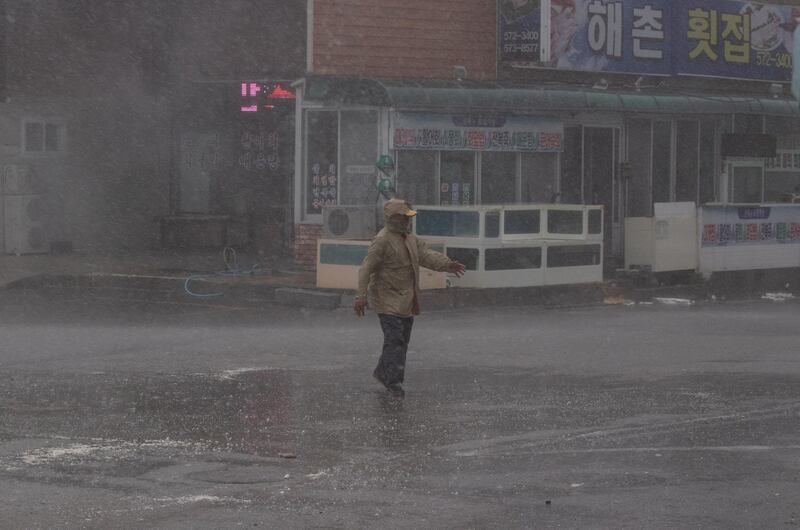 A fishman walks through heavy rain during weather caused by typhoon Haishen, near Imwon harbor in Donnghae, Gangwon-do province, South Korea.  EPA