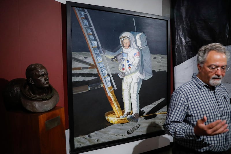 A portrait of astronaut Neil Armstrong stepping onto the surface of the moon is displayed behind museum director Dante Centuori.