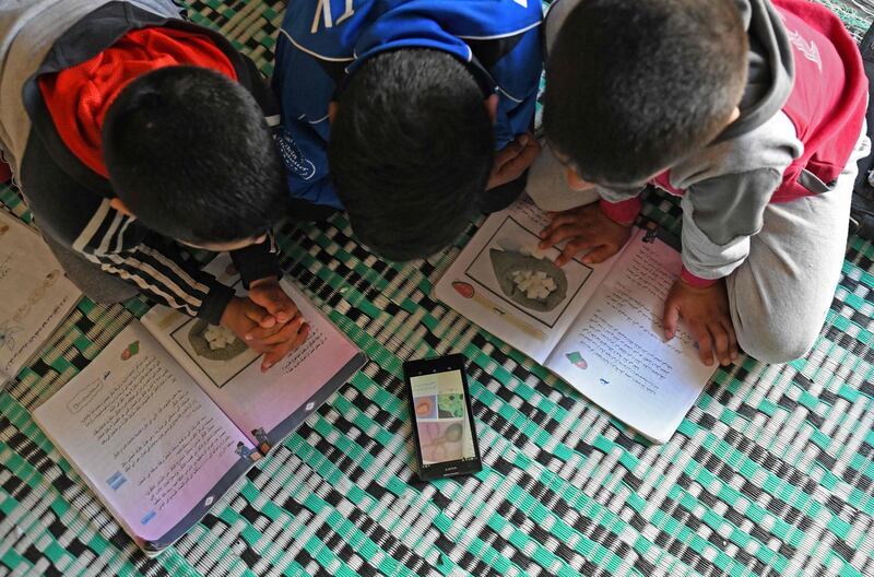 Displaced Syrian boys study online materials provided by their teachers on Whatsapp following restrictions to curb the spread of coronavirus, at the Muhammadiya camp on the outskirts of Afrin city near the Turkish border.  AFP