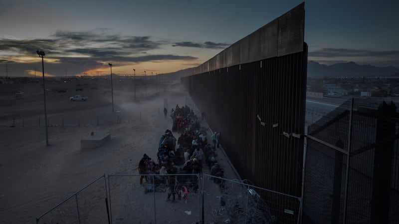 Migrants enduring cold and blustery weather as they surrender to US border officials after breaching a razor wire-topped fence along the bank of the Rio Grande river in El Paso, Texas. Reuters