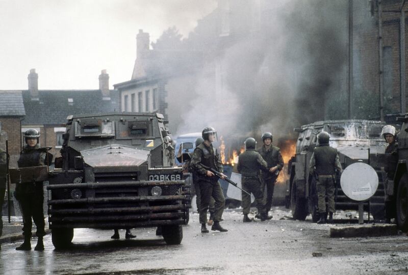 British troops with armoured vehicles surround a blazing barricade near the Andersonstown Police Station in Belfast in 1979. AP