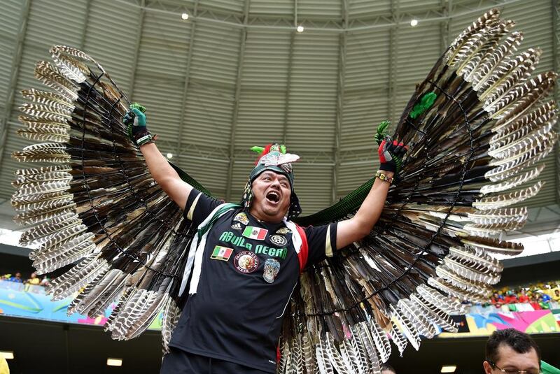 A Mexico fan poses with feathered wings before his team's match against Brazil on Tuesday at the 2014 World Cup in Fortaleza, Brazil. Buda Mendes / Getty Images