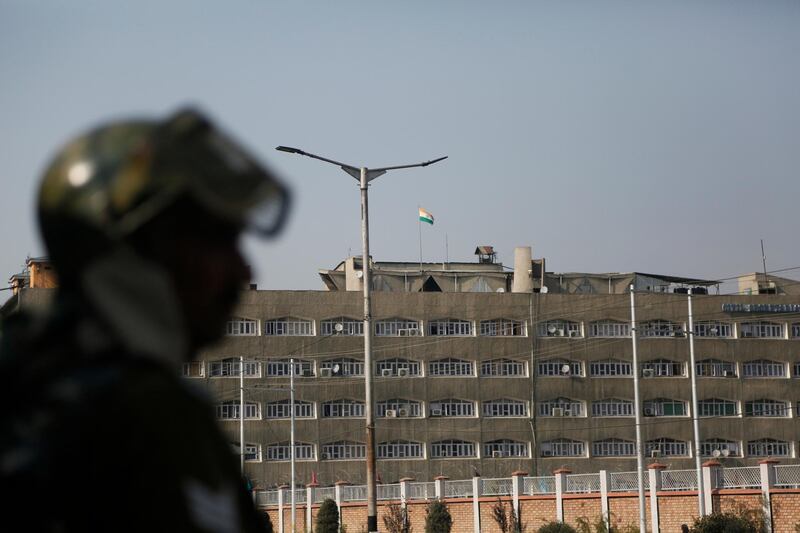An Indian paramilitary soldier stands guard as the Indian national flag flies atop the government secretariat in Srinagar, Indian controlled Kashmir, Thursday, Oct. 31, 2019. India on Thursday formally implemented legislation approved by Parliament in early August that removes Indian-controlled Kashmir's semi-autonomous status and begins direct federal rule of the disputed area amid a harsh security lockdown and widespread public disenchantment. The most visible change is the absence of Kashmir's own flag and constitution, which were eliminated as part of the region's new status. (AP Photo/Mukhtar Khan)
