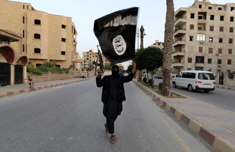 An ISIL supporter waves the group's flag in Raqqa on June 29, 2014. Reuters