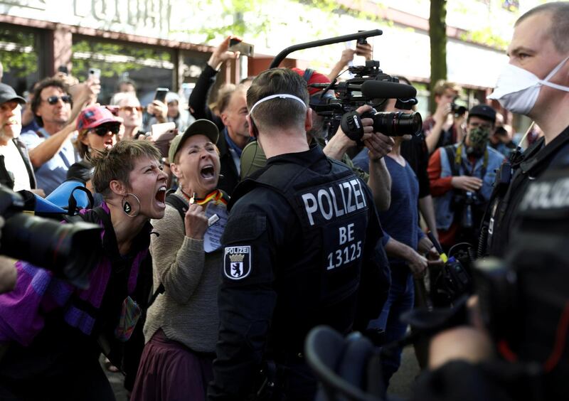 People shout at police officers during a demonstration of conspiracy theorists as other demonstrators protest against the lockdown imposed to slow the spread of coronavirus, in Berlin, Germany. Reuters