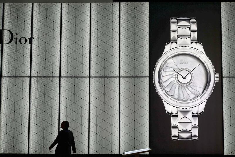 A visitor is seen in silhouette next to the stand of French watchmaker Dior during the 42nd edition of Baselworld. Fabrice Coffrini / AFP