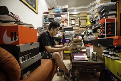 EDITOR'S NOTE: ONE TIME USE ONLY IN CONNECTION WITH 'China’s Sneakerheads Chase 6,600% Returns Flipping Air Jordans' by Bloomberg News. EDITORIAL USE ONLY. NO SALES. NO ARCHIVING. Tian Hao, a sneaker collector and trader, browses a trading app while sitting among boxes of sports shoes crammed into the living room of his home in Beijing, China, on Wednesday, Sept. 25, 2019. Across China, more than 10 million monthly active users frequent online-resale apps for sneakers, such as Poizon, Nice and DoNew, according to Chinese data-mining company QuestMobile. While many products suffer from the effects of the trade war, pairs of collectible sneakers are flying off the shelves, and that's attracting the attention of U.S. sneaker exchanges like StockX and GOAT. Photographer: Qilai Shen/Bloomberg