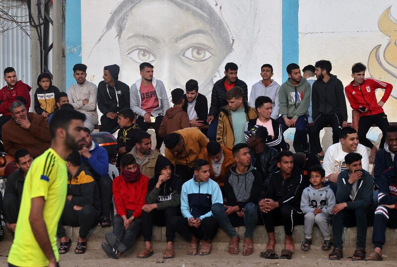 Palestinians watch as youths play football at a refugee camp in Rafah in the southern Gaza Strip. All photos: AFP