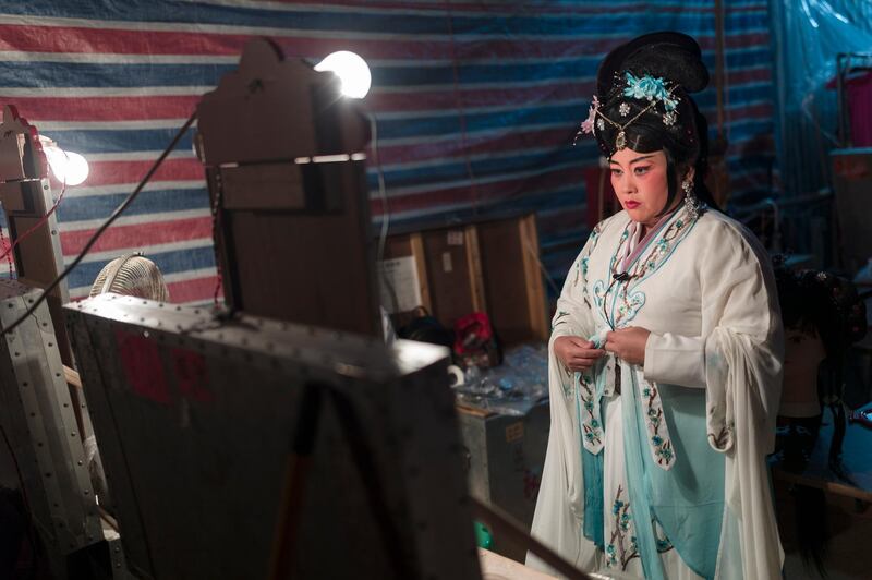 One Chiu Chow performer makes some final adjustments to her costume. EPA