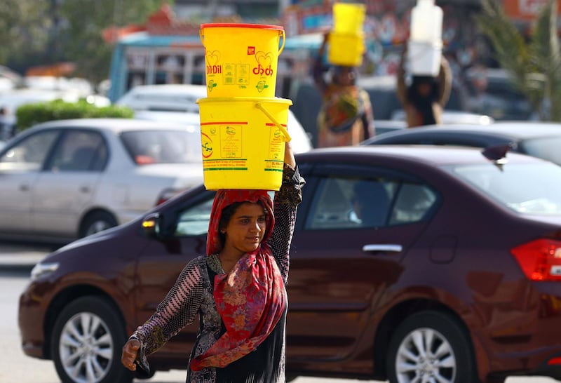 epa06618347 Pakistani women carry drinking water to home on the eve of World Water Day, in Karachi, Pakistan, 21 March 2018. International World Water Day is held annually on 22 March as a means of highlighting the importance of freshwater and its management.  EPA/SHAHZAIB AKBER
