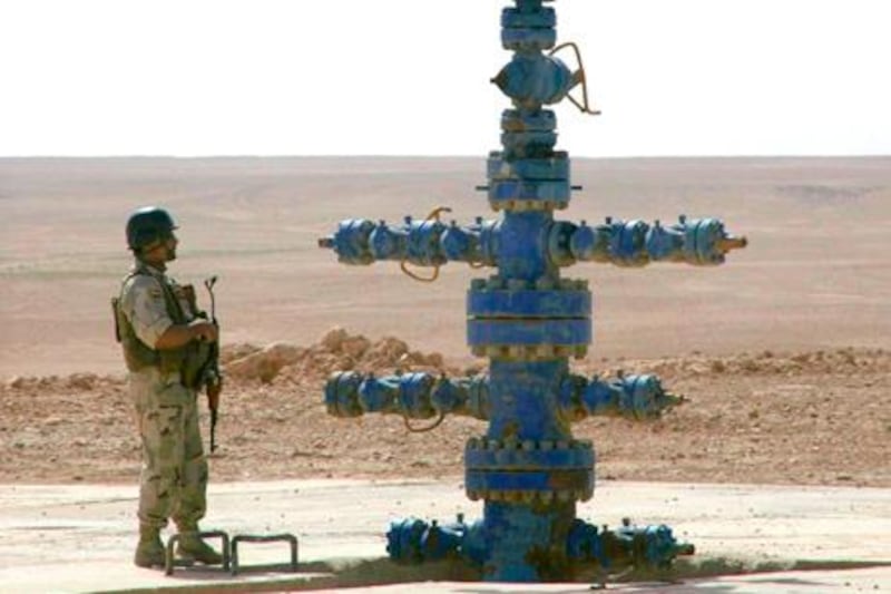 An Iraqi soldier stands guard next to a gas pipeline inside the Akkas gas field in the western desert of Iraq October 19, 2010. Iraq on Wednesday offered up three of its gas fields in its third energy auction since the 2003 U.S.-led invasion, hoping to leap into the ranks of top energy producers and shake off a legacy of war and isolation. Picture taken October 19, 2010. REUTERS/Ali al-Mashhdani (IRAQ - Tags: ENERGY BUSINESS POLITICS IMAGES OF THE DAY)