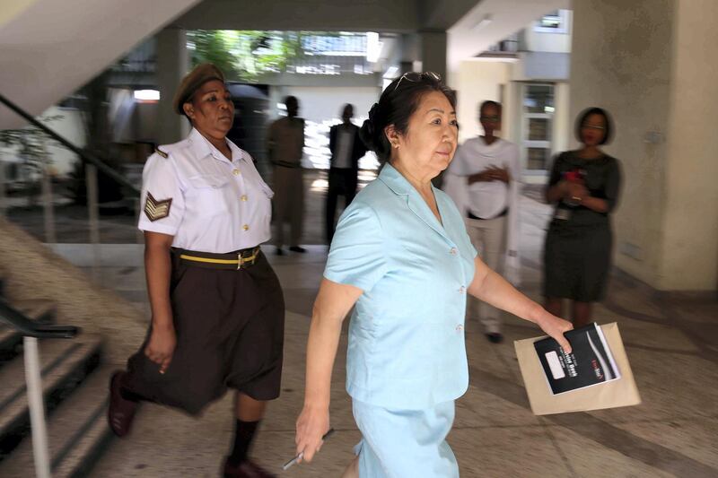 The 66-year-old, Yang Fenglan, is being escorted by Tanzania’s Prison warden as she was brought at Kisutu Resident’s Magistrate Court in Dar es Salaam, Friday November 04, 2016. - The Chinese woman nicknamed the “Ivory Queen” who is accused of leading one of Africa's biggest ivory smuggling rings, responsible for more than 700 elephant tusks worth $2.5m (£1.7m) illegally leaving Tanzania for the Far East, was brought to the court for the case hearing. However the court has adjoined the hearing until November 15, 2016, due to the absence of the prosecution’s first witness. (Photo by Said KHALFAN / AFP)