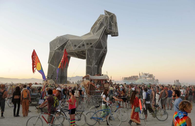 People gather around the Trojan Horse at it is pulled across the "playa" at the Burning Man festival in Gerlach, Nev. on Friday, Sept. 2, 2011. (AP Photo/Reno Gazette-Journal, Andy Barron) *** Local Caption ***  Burning Man Festival.JPEG-08cef.jpg