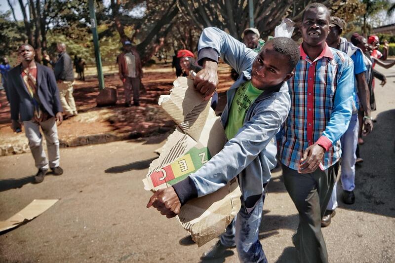 Supporters of the opposition party Movement for Democratic Change (MDC), tear up ballot booths as they demand results of general election in Harare. AFP