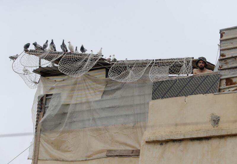 A Lebanese man stands by his pigeon pen on the roof of his house in the historic part of the southern coastal city of Saida. Lebanon's President called on international donors to provide financial assistance to the crisis-hit country as it grapples with a severe economic downturn compounded by the novel coronavirus pandemic. AFP