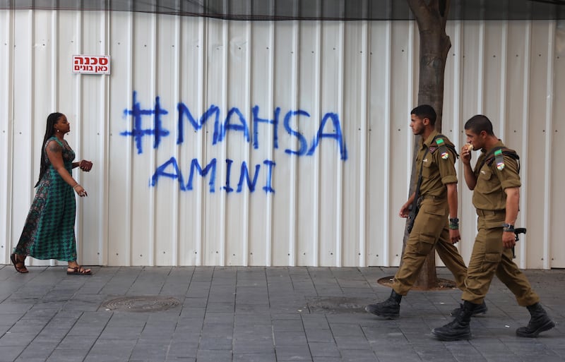 People walk by graffiti in support of the protests triggered by Amini's death, in Jerusalem. EPA