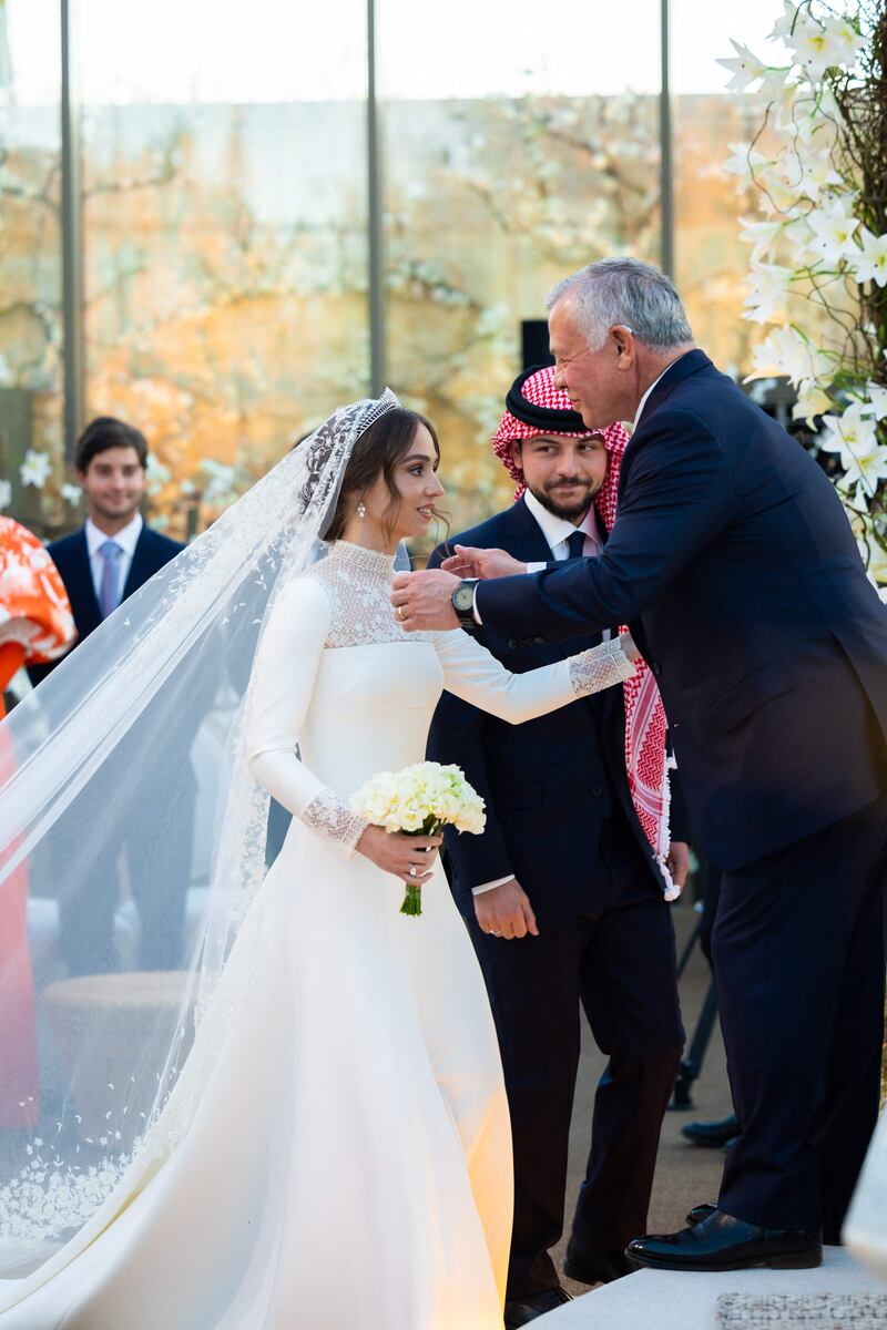 Crown Prince Hussein looks on as his father, King Abdullah, congratulates Princess Iman. AFP 