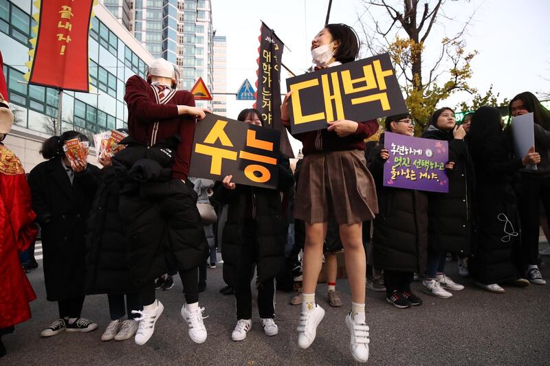 South Korean high school girls cheer on their senior classmates taking the college entrance exam in Seoul, South Korea. Getty Images