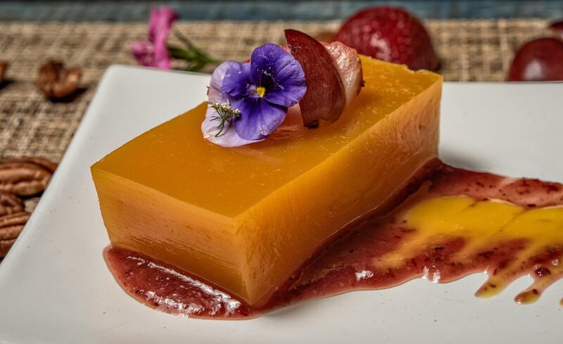 Mango and orange jellies garnished with edible flowers, strawberries and grapes, at the Placido restaurant in Mexico City on September 7, 2016. (Photo by OMAR TORRES / AFP)