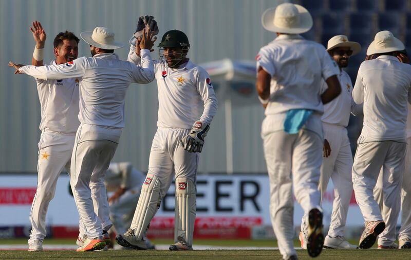 Pakistan's Yasir Shah and Sarfraz Ahmed celebrate dismissal of Sri Lanka's batsman Dinesh Chandimal during their fourth day at First Test cricket match in Abu Dhabi, United Arab Emirates, Sunday, Oct. 1, 2017. (AP Photo/Kamran Jebreili)