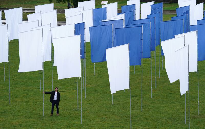 Artist Luke Jerram walks through his installation 'In Memoriam', in Bristol, west England. It was created to remember the losses experienced during the Covid-19 pandemic, and is made up of more than 100 flags made from NHS hospital bed sheets. PA