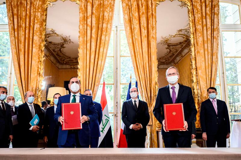 French Prime Minister Jean Castex  and Iraqi Prime Minister Mustafa al-Kadhimi stand as CEO of Alstom Henri Poupart-Lafarge and Iraqi Transport Minister  Nasser Hussain Al-Bandar pose during a contracts and economic agreements signing ceremony at the Hotel de Matignon in Paris, after a meeting between the French and Iraqi prime ministers.   AFP