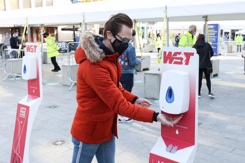 A spectator uses hand sanitiser at the entrance before day one of the World Snooker Championships. PA