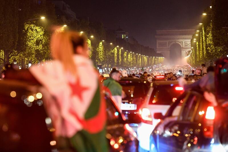 Algeria's supporters react to their success with the Algerian national flag in front of the Arc de Triomphe. AFP