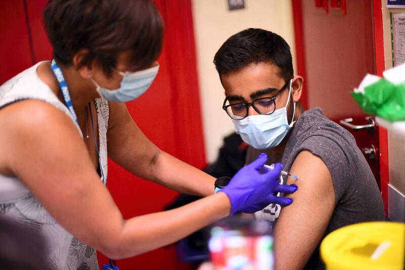 A student is given a dose of the Pfizer/BioNTech Covid-19 vaccine at a vaccination centre at the Hunter Street Health Centre in London on June 5, 2021.  The UK government are set to decide on June 14 whether their plan to completely lift coronavirus restrictions will go ahead as scheduled on June 21 amid concern over rising infections.  / AFP / DANIEL LEAL-OLIVAS
