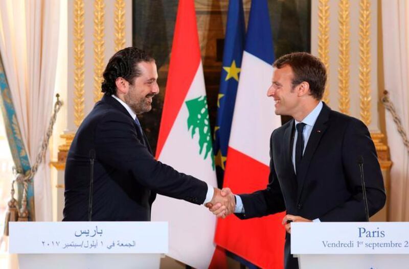 This file photo taken on September 1, 2017 shows French President Emmanuel Macron (R) shaking hands with Lebanese Prime Minister Saad Hariri during a press conference at the Murat Lounge in the Elysee Palace in Paris. AFP / Ludovic Marin
