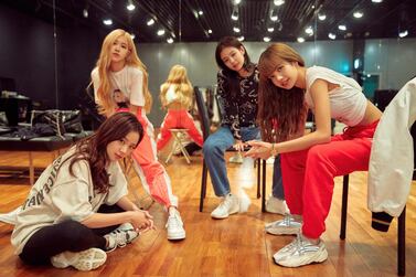 This image released by Netflix shows, from left, Jisoo, seated from left, Rose, Jennie and Lisa of the K-Pop band Blackpink. Netflix via AP