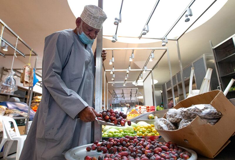 A vendor wearing a face mask against the coronavirus sells dates at the Mutrah Souq in the Omani capital Muscat.   AFP