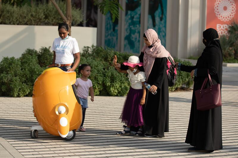 Visitors interacting with one of the Opti robot at Expo 2020 Dubai. Photo: Christophe Viseux / Expo 2020 Dubai