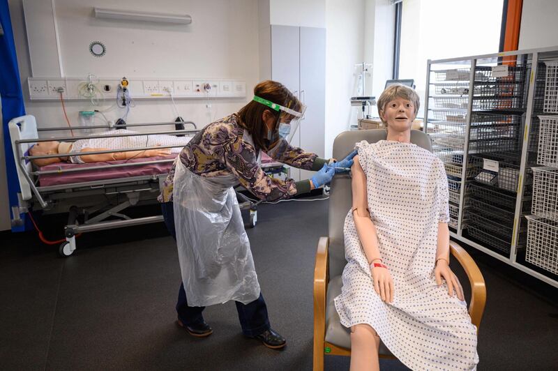 Volunteers practices administering an intramuscular injection with a training model during vaccinator training to prepare volunteers to be deployed to assist in the national Covid-19 vaccination programme, at the University of Hull. AFP