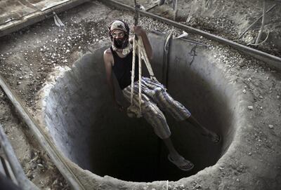 A man is lowered into a smuggling tunnel between the Gaza Strip and Egypt. EPA