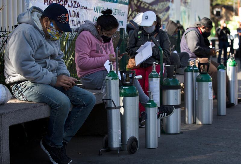 People wait to refill oxygen tanks for relatives sick with COVID-19 in the Iztapalapa district of Mexico City. The city is offering free oxygen refills for patients with COVID-19. AP