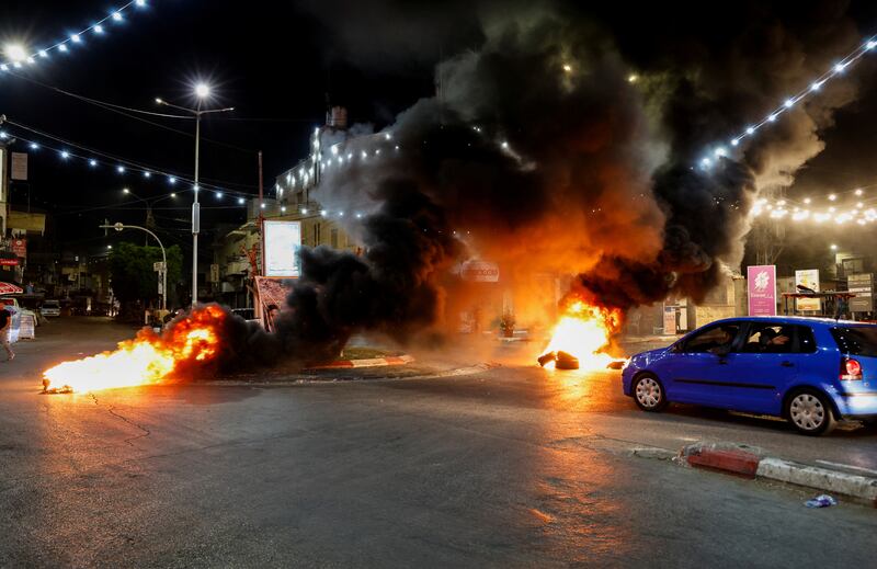 Tyres on fire in a street during an Israeli military raid. Reuters