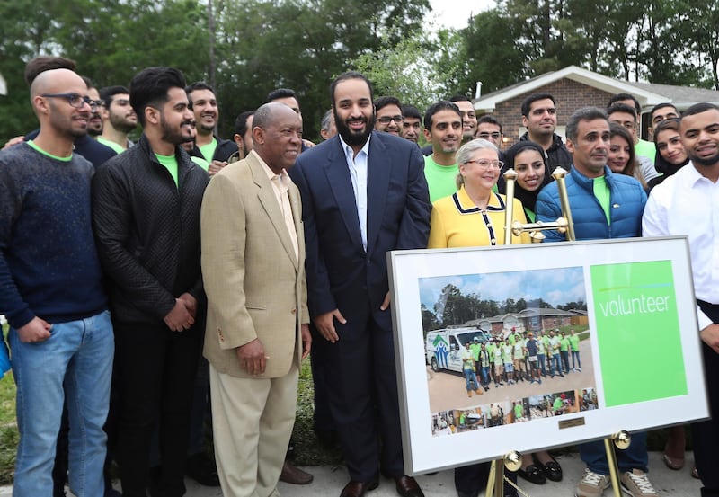 Houston Mayor Sylvester Turner, third from left, and Saudi Crown Prince Mohammed bin Salman pose with volunteers in front of a Habitat for Humanity home  in Houston. The subdivision is made up of Habitat for Humanity homes that were flooded a year earlier. Volunteers from the U.S.-based subsidiary of Saudi Aramco had helped residents in the neighborhood clean up after the storm damage. Steve Gonzales / AP Photo