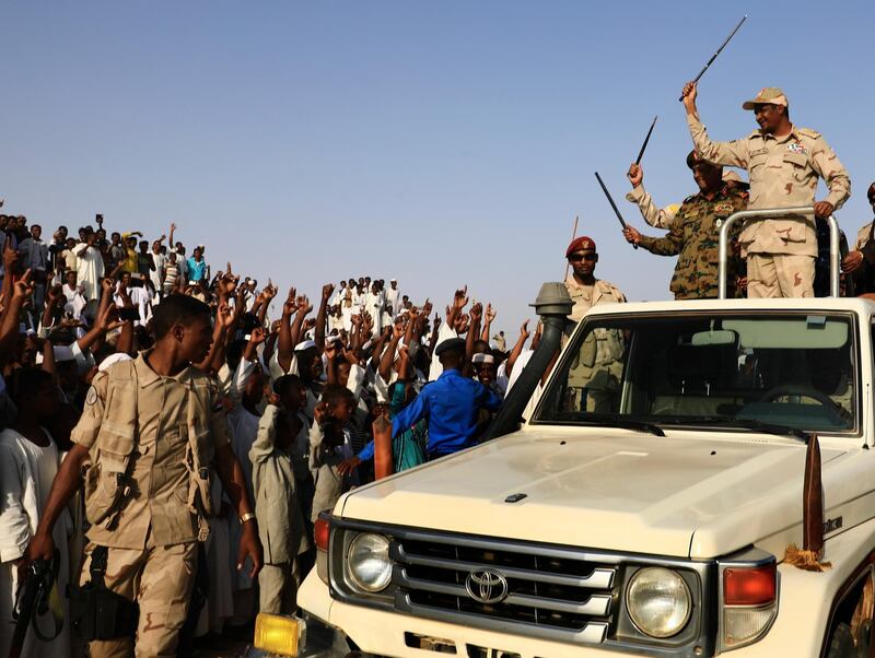 Gen Mohammed Hamdan Dagalo, top right, the deputy head of the military council that assumed power in Sudan after the overthrow of President Omar al-Bashir, stands on military vehicle as he waves to his supporters during a rally, in Garawee town, north of Sudan.  AP