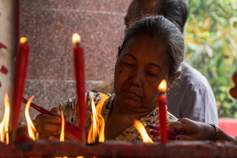 The pilgrims light red candles and burn incense sticks – one for themselves and three for their family 