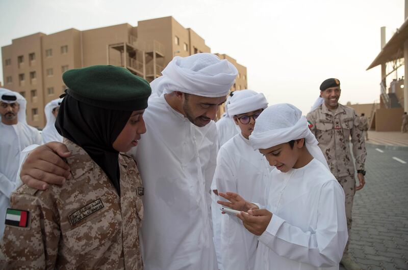 Sheikh Abdullah bin Zayed, Minister of Foreign Affairs and International Cooperation, speaks with his sons Sheikh Zayed bin Abdullah (R), Sheikh Mohammed bin Abdullah (back) and daughter Sheikha Fatima bint Abdullah (L), during the volunteer cadet summer course graduation ceremony at Sieh Al Hama military camp. Mohammed Al Hammadi / Crown Prince Court - Abu Dhabi 