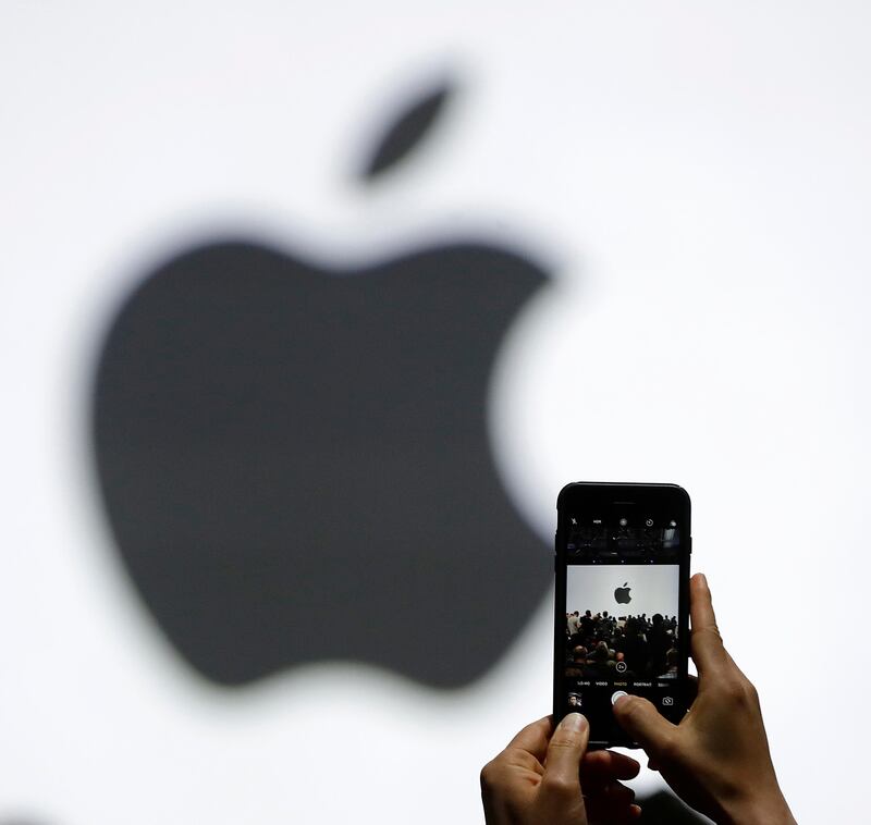 FILE - In this Monday, June 5, 2017, file photo, a person takes a photo of an Apple logo before an announcement of new products at the Apple Worldwide Developers Conference in San Jose, Calif. Apple is getting ready to use iPhone cameras as an entryway into the strange world of augmented reality, taking the trend-setting company down an avenue that could usher in a new era in technology. (AP Photo/Marcio Jose Sanchez, File)