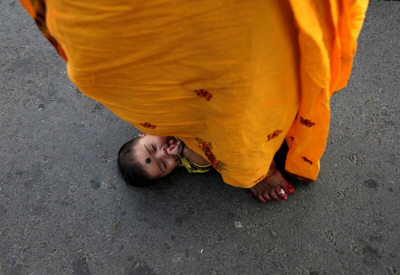 A woman steps over an infant in a ritual seeking blessings for the infant from the Sun god in Kolkata. Reuters