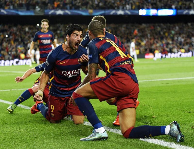 Luis Suarez celebrates with teammates after striking late to seal a narrow win over Bayer Leverkusen. LLuis Gene / AFP 

