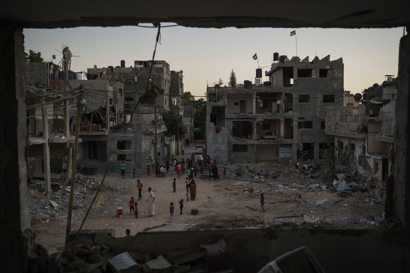 Palestinians walk along Al Baali Street, near the debris of homes heavily damaged by Israeli air strikes. Since 2008, more than 4,000 Palestinians have been killed in four wars, the UN says. AP