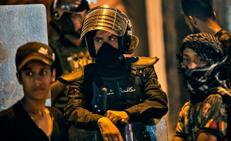 Anti-government protesters gather while Iraqi security forces prepare to open protesters' site in Basra. AP