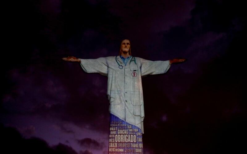 The statue of Christ the Redeemer is lit up with the image of a medical scrub and the word "thank you" in different languages during an Easter Sunday event  in Rio de Janeiro, Brazil. Reuters