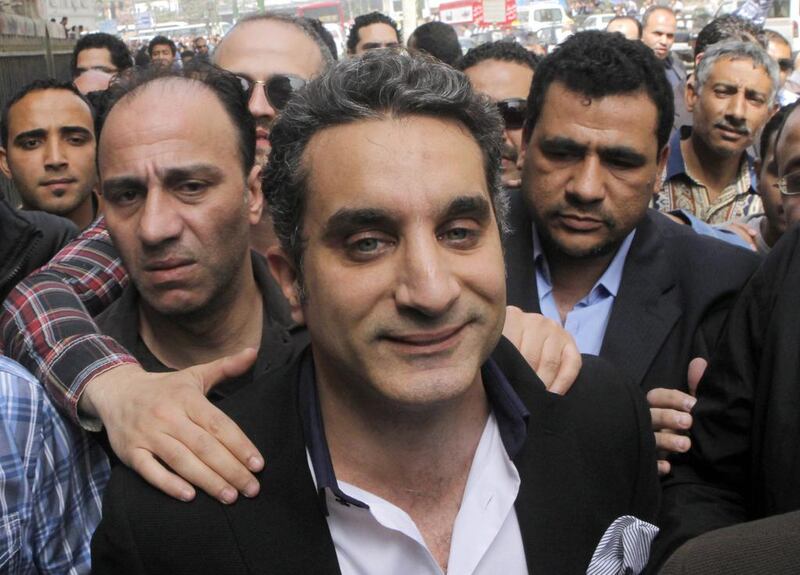 A bodyguard secures popular Egyptian television satirist Bassem Youssef, who has come to be known as Egypt's Jon Stewart, as he enters Egypt's state prosecutors office on March 31, 2013.  Amr Nabil / AP Photo